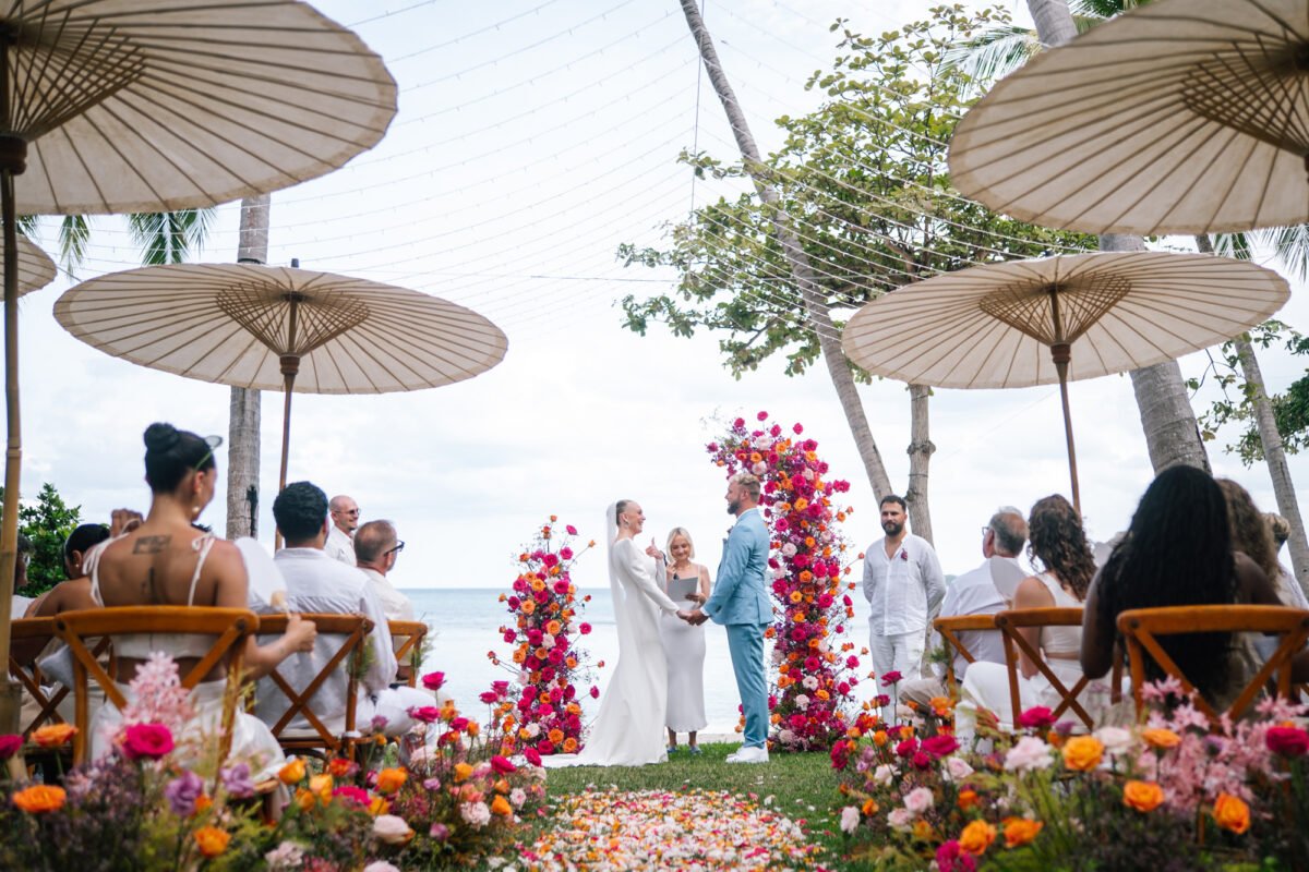 Beach wedding ceremony with white parasols and floral aisle, Koh Samui wedding photographer