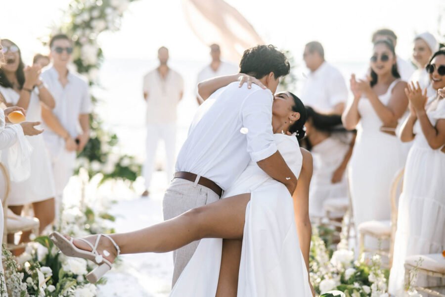 Bride and groom first kiss as guests applaud on a Koh Samui beach