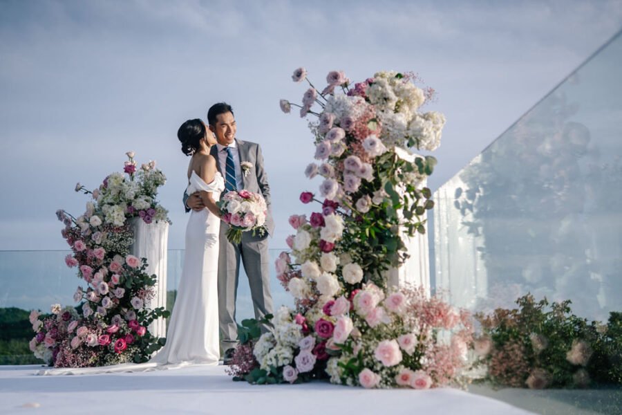 Bride and groom at a floral wedding arch, elegant Koh Samui wedding