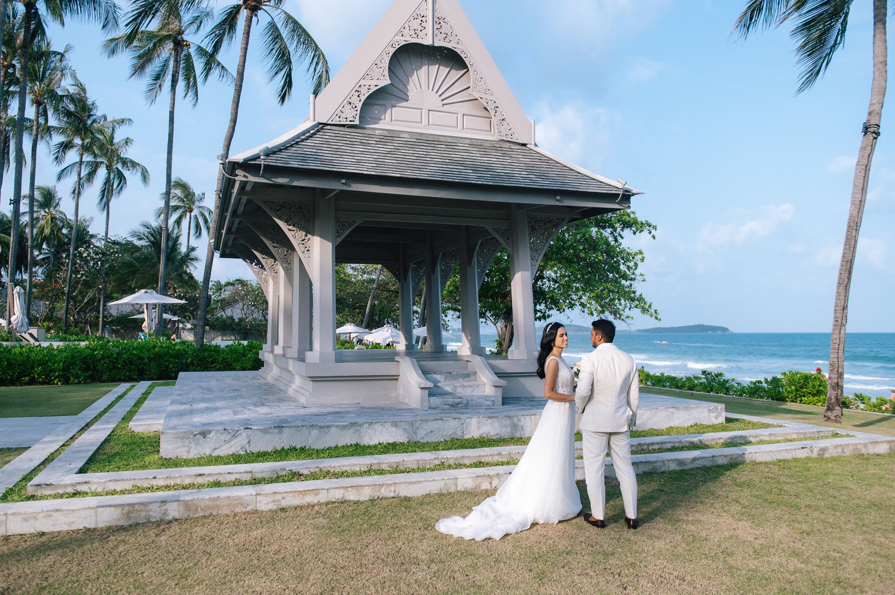 Couple walking past a Thai beach pavilion, Koh Samui elopement photographer